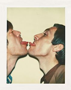 two young men are kissing each other with their mouths wide open and tongue hanging out