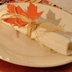 a white plate topped with a piece of cake next to a fork and napkin on top of a wooden table