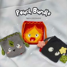 three small crocheted bags with faces on them, one has a face and the other is a cat