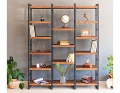 a book shelf with books and other items on it in front of a white wall