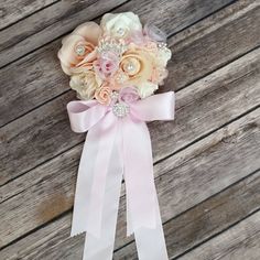 a bridal bouquet with pink and white flowers on a wooden background, ready to be used as a boutonniere