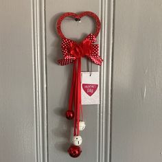 a door hanger with a heart and two bells attached to it