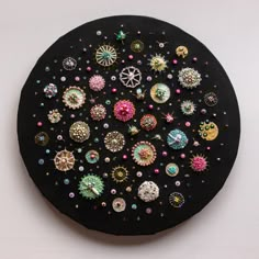 a black plate topped with lots of different colored buttons