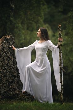 This white fairy dress is made of immaculate white fabric with cotton lace details on neckline, chest and sleeves. It has a silky linen, as well, and it closes with a zipper. It also can be very nicely accessorized with other medieval items like belts or corsets to obtain an unique outfit. This is custom-made to clients measurements and I require 2 weeks to finish it Please contact me for further assistance to discuss measurements and how to purchase a made to order outfit. I will be happy to answer all your questions. For orders to Europe, the package arrives in 5-7 days For orders to US, Canada the package arrives in 10-14 days Medieval Style White Wedding Dress, White Fitted Elven Medieval Dress, Elegant White Medieval Dress For Larp, White Bell Sleeve Wedding Dresses, White Flowy Dress Goddesses, Fairy White Dress, White Medieval Dress, Viking Wedding Dress, Medieval Items