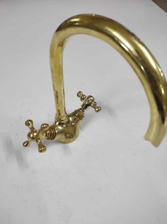 an old brass faucet is sitting on a white surface