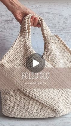 a hand holding a knitted bag with the words bolso go written on it