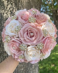 the bride's bouquet is made up of pink and white roses with crystal brooches