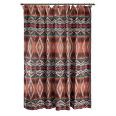 a shower curtain with an orange and blue pattern on it, hanging from a metal rod