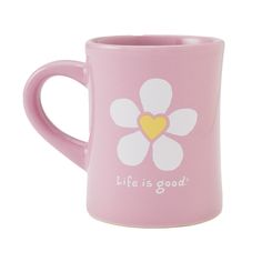 a pink coffee mug with a white flower on the side and words life is good