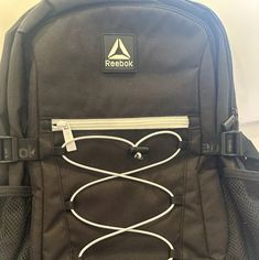 a black backpack with white cords attached to it