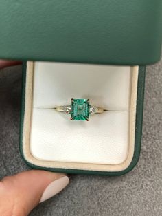 A classic Colombian emerald and diamond engagement, statement, or right-hand ring. Dexterously crafted in gleaming 14K gold this ring features a 1.81-carat natural Colombian emerald-emerald cut from the famous Chivor mines. Set in a secure prong setting, this extraordinary emerald has a bright green color and glow. This emerald has very good eye clarity with natural Jardins that occur in all earth-mined emeralds. Pear diamonds weighing 0.30pts total accent on either side of the emerald. Setting: Small Green Engagement Ring, Colombian Emerald Engagement Ring, Emerald Pear Engagement Ring, Crazy Rich Asians Ring, Wedding Manifestation, Square Emerald Ring, Wedding Rings Emerald, Three Stone Engagement Rings Emerald, Emerald Cut Emerald Ring