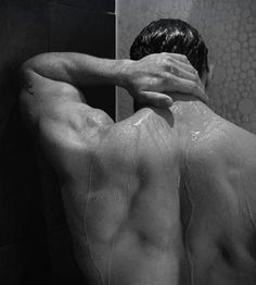 a man with his back turned to the shower