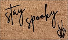 a door mat with the words stay spooky written in black ink on it