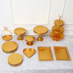 a table topped with lots of gold colored plates and trays next to each other