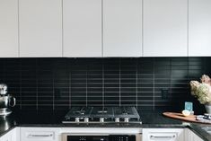 a black and white kitchen with an oven, counter tops, and cabinets in it