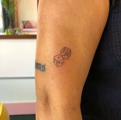 a woman with a tattoo on her arm has two dices in the shape of numbers