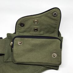 an olive green canvas pouch with black zippers on the side and two metal buttons at the bottom