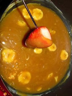 a bowl filled with bananas and a straw on top of it, next to a spoon