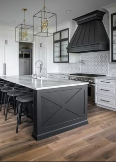 a large kitchen with an island, stove and chairs in front of the counter top