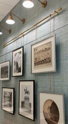 several framed photographs hang on the wall in an office setting with gold fixtures and lights