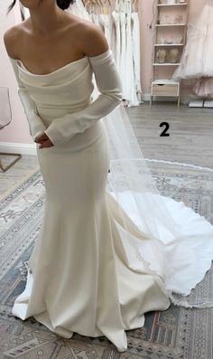 a woman in a wedding dress is looking at herself