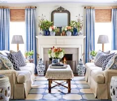 a living room filled with furniture and a fire place in front of a mirror on the wall