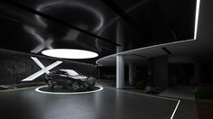 a car is parked in the middle of a large room with lights on it's ceiling