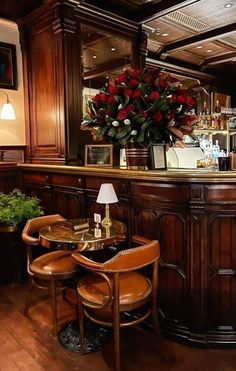 a bar with two stools and a flower arrangement on the counter