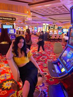 a woman sitting on a chair in front of slot machines