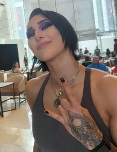 a woman with black hair and tattoos posing for the camera