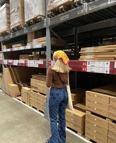 a woman with a donut on her head is standing in front of shelves full of boxes