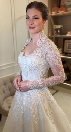 a woman in a wedding dress posing for the camera with her hands on her hips