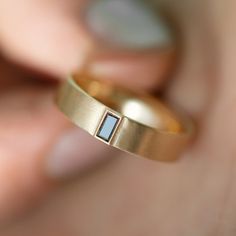 a close up of a person's gold ring with a blue stone embedded in it