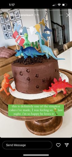 a chocolate cake with dinosaur decorations on top and a message from someone else to it