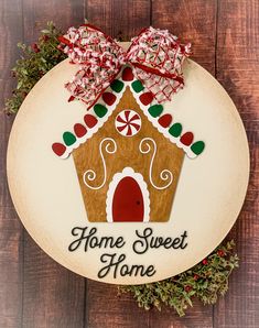 a wooden sign with a gingerbread house on it that says home sweet home and decorated with candy canes