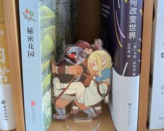 a book shelf filled with books and anime figurines on top of each other