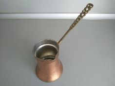 a metal cup with a chain hanging from it