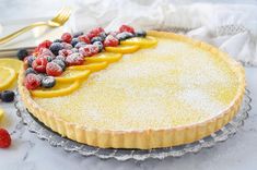 a lemon tart with berries and raspberries on top