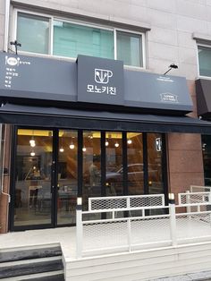 the outside of a restaurant with black awnings and white steps leading up to it