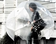 a woman is holding an umbrella outside in the rain with polka dot print on it