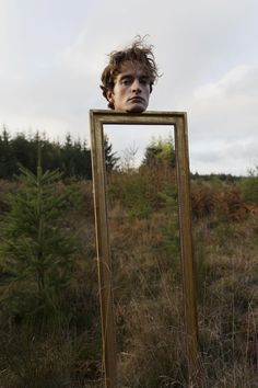 a person holding a mirror in front of their face with the caption strange / inspired photo somewhere following