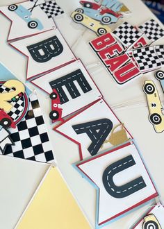 cars and trucks are displayed on the table with paper garlands that spell out their name