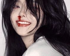 a woman with black hair and blood on her face