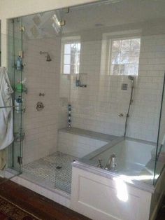 a bathroom with a walk in shower next to a bath tub