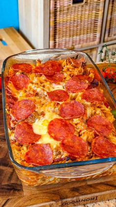 pepperoni and cheese casserole in a glass dish on a wooden counter top