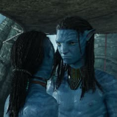 two people dressed as avatars standing in front of a cave