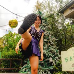 a woman standing on one leg with her feet in the air