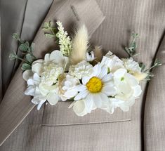 a boutonniere with white flowers and feathers