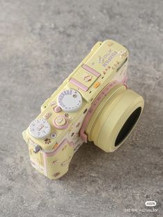 a yellow camera sitting on top of a cement floor