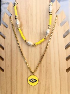 A gold evil eye necklace with tiny zircons and an adjustable necklace with yellow beads, gold hematite beads and pearls that can be a choker or a longer necklace for every woman. You can wear them together or separetely as well. In Christina Christi Jewels store you can see more than 100 designs in Women's Necklaces. You can have them in 2-4 Days with DHL EXPRESS SHIPPING MATERIALS - Metal Parts. - Pearls. - Gold Hematite Beads. - Different type of beads in different colors. - Metal Evil Eye fro Gold Beaded Necklaces With Evil Eye For Gifts, Trendy Yellow Necklace With Tiny Beads, Round Evil Eye, Evil Eye Necklace Gold, Yellow Necklace, Protection Necklace, Eye Pendant, Hematite Beads, Evil Eye Pendant